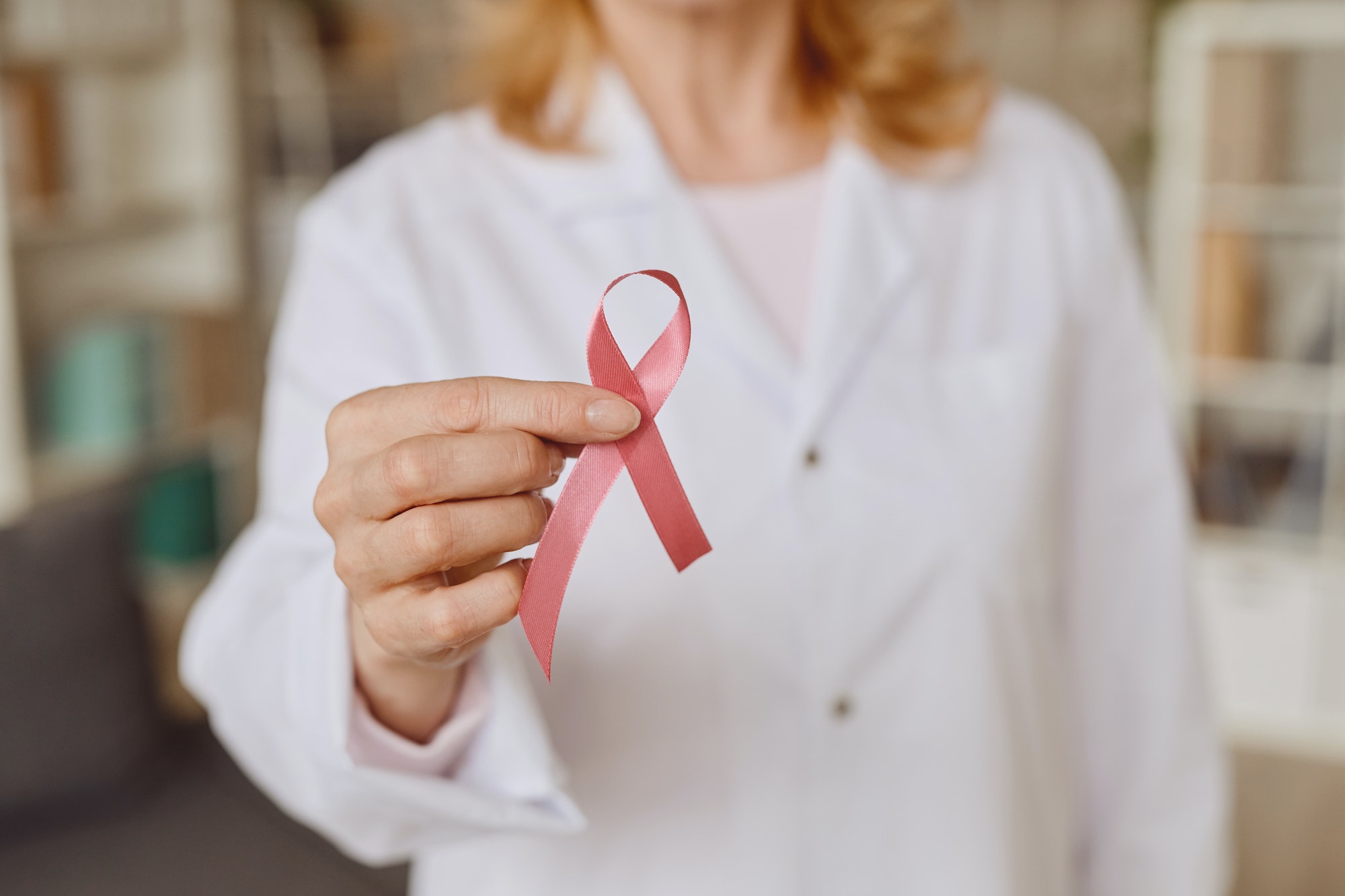 Female Doctor Holding Pink Ribbon