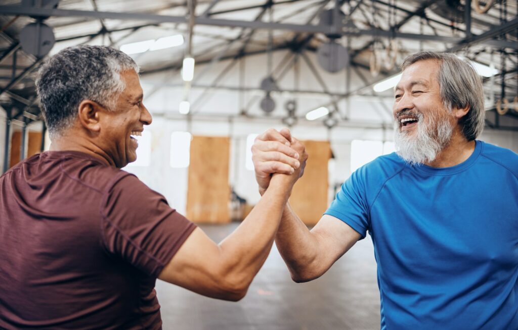 Handshake, support or mature men in workout gym, training exercise or healthcare wellness or succes