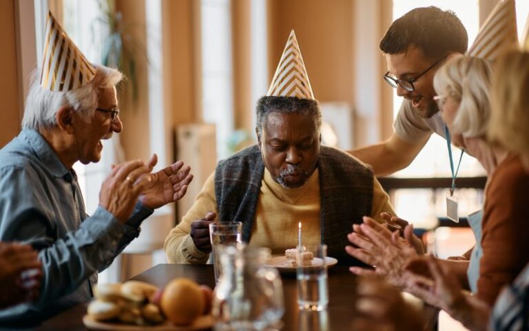 black senior man blowing birthday candle on cake in nursing home qkhqllmwg9ycbsglpypstd52qd987se7fwgxnaz5ag